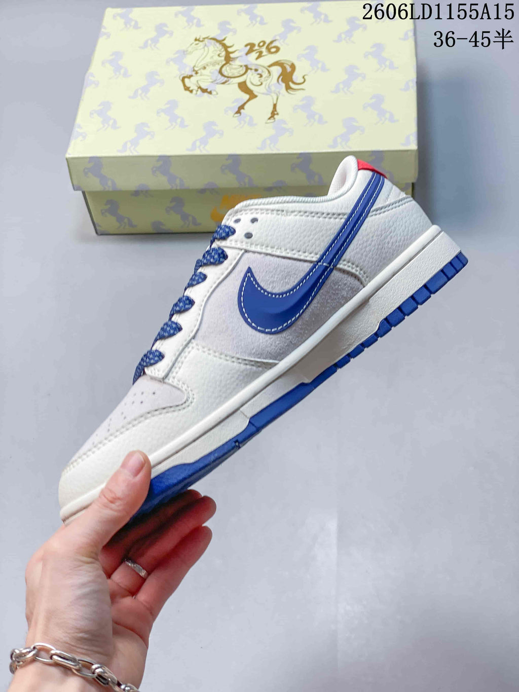 Side view of a white low-top sneaker with blue Swoosh and blue outsole