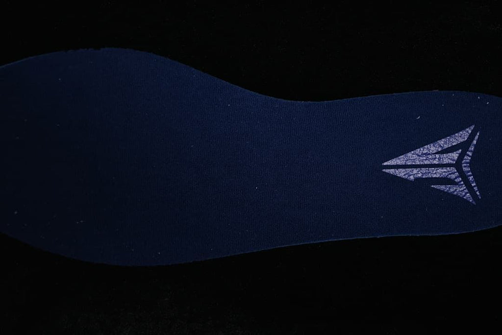Close-up of a dark fabric shoe component with a logo