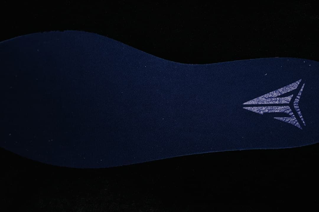 Close-up of a dark fabric shoe component with a logo