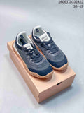 Pair of gray and navy Miu Miu Tyre low-top sneakers with tan-colored outsoles, viewed from above.