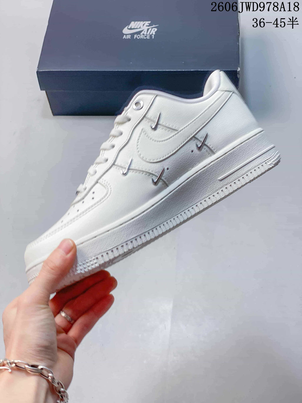 Side view showing the white upper and metallic accents on a Nike Air Force 1 sneaker