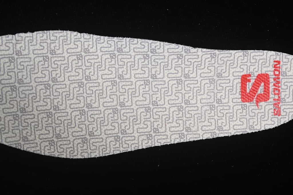 Close-up of a patterned shoe insert with red Salomon branding