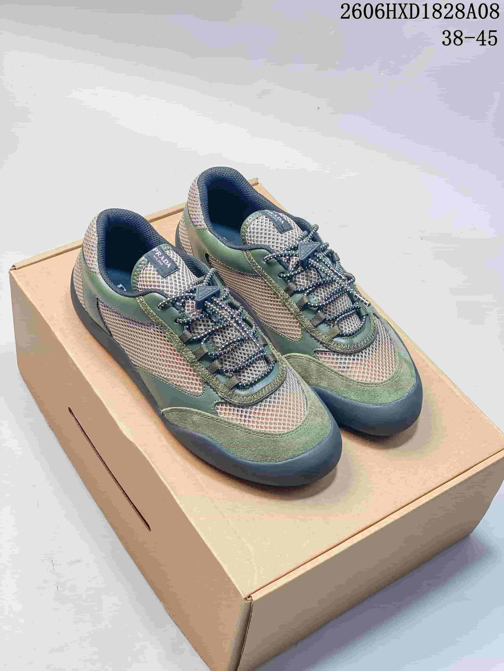 Green and beige mesh trainer sneakers shown from above on a box.