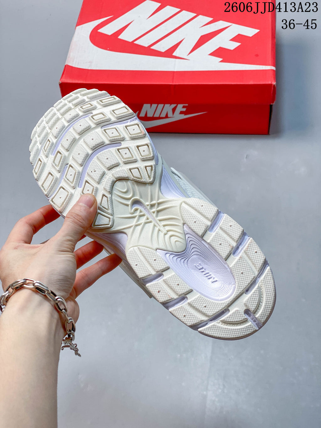 Close-up of the patterned outsole on a light-colored Nike Air Zoom Winflo 12 shoe.
