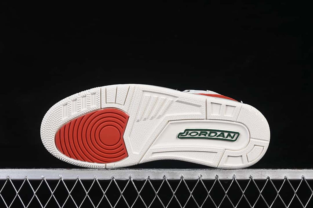 Underside view showing a white outsole with a red circular traction area and green branding