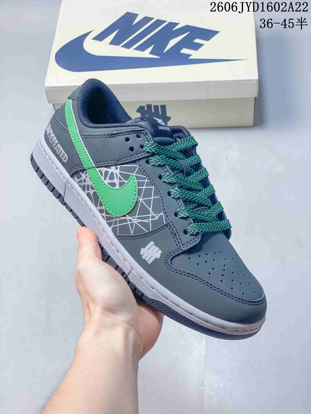 Gray low-top sneaker with green accents, patterned side panel and green laces
