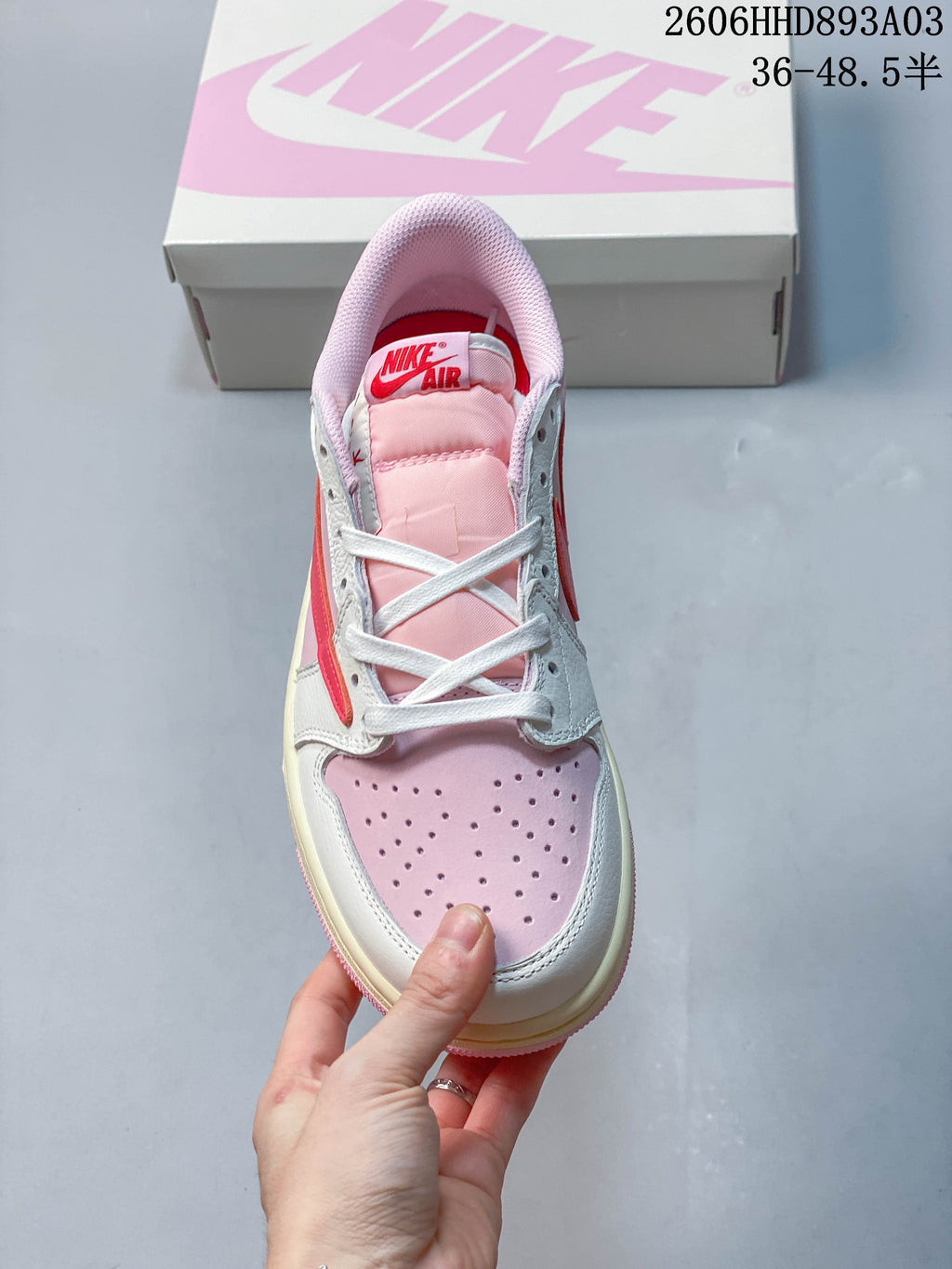 Top view of a pink and white low-top sneaker with white laces and a red tongue label; image overlay states a size range.