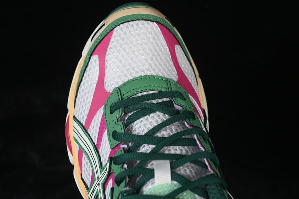 Top-down view of the white mesh toe box with pink panels and green laces