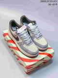 Pair of off-white and gray Nike Air Force 1 Low sneakers on a red-and-cream striped box