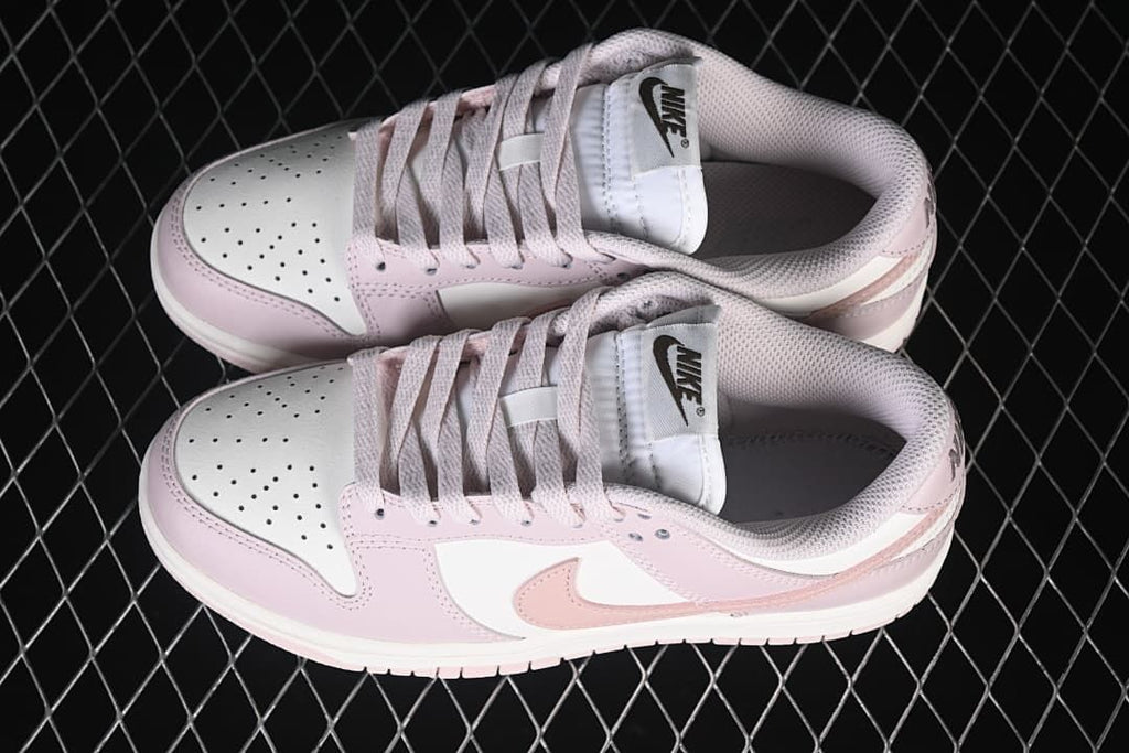 Pair of pink and white low-top sneakers viewed from above