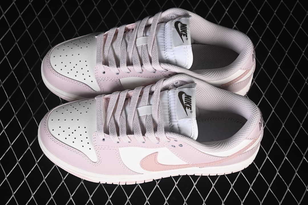 Pair of pink and white low-top sneakers viewed from above
