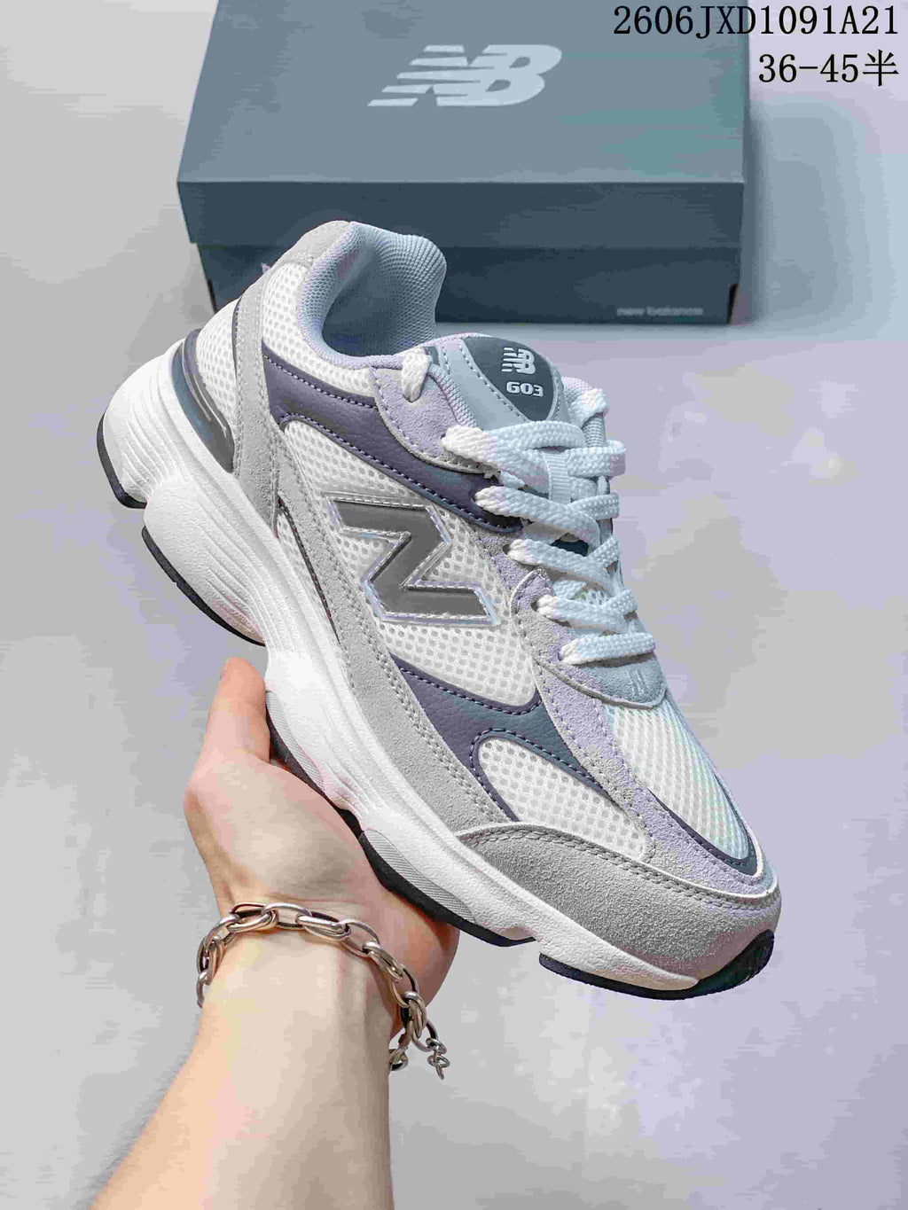 Angled side view of a gray and white New Balance sneaker