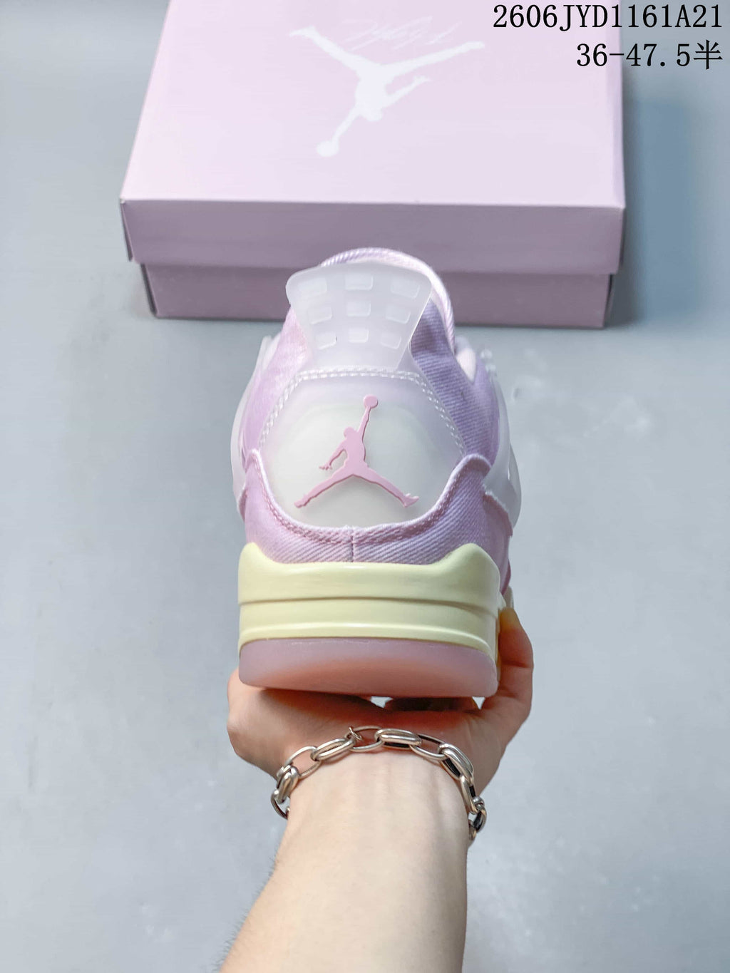 Rear view of a pink Jordan sneaker with a pale heel panel and contrasting midsole.