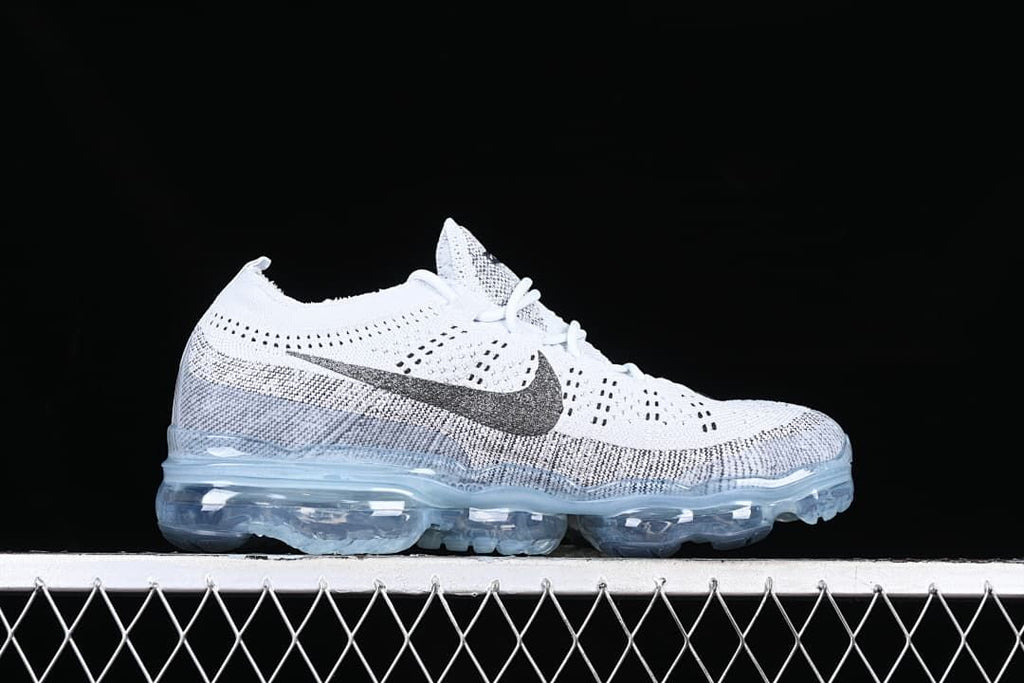Side profile of the white and gray sneaker with a dark Swoosh and visible sole cushioning.