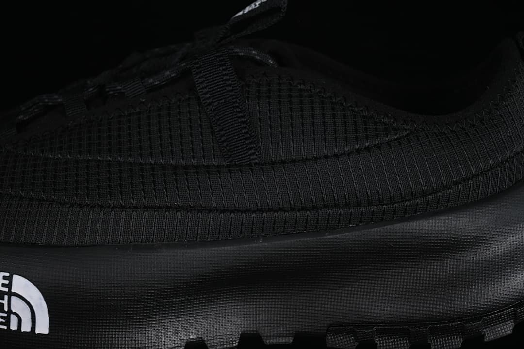Close-up of the black upper, side panel, and outsole
