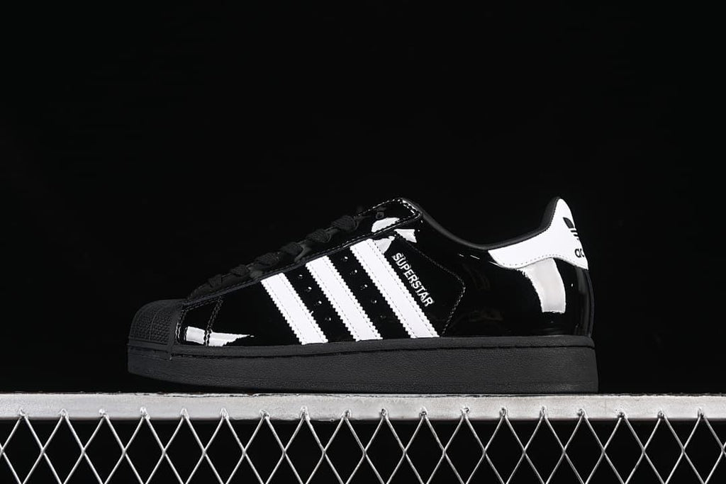 Side view of a black Adidas Superstar II sneaker with white stripes and heel detail