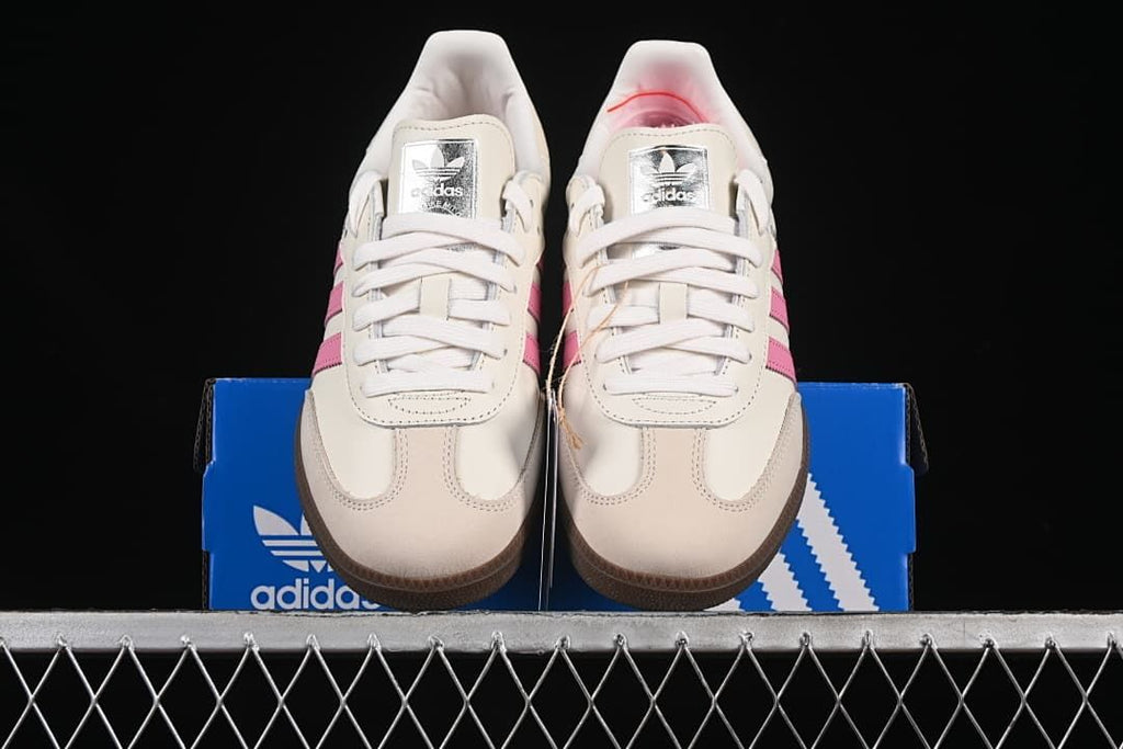 Front view of the pair showing white laces, pink stripes, and gum toe edges