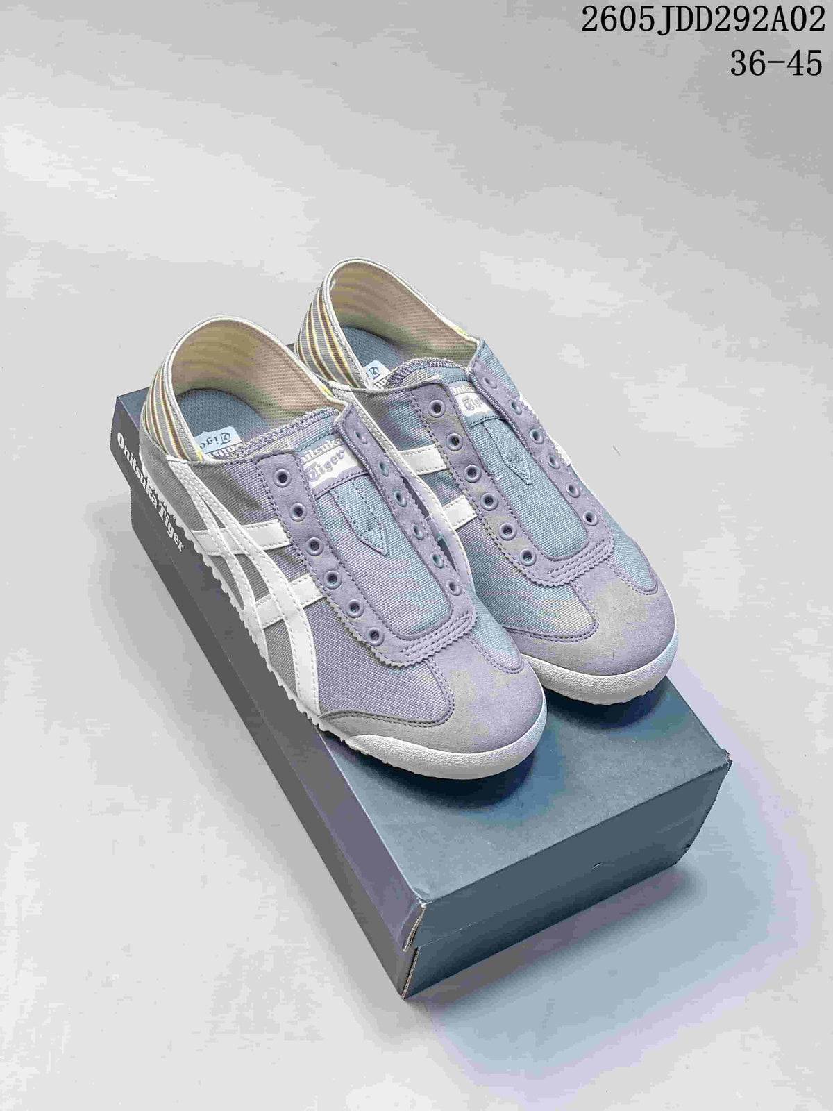 Pair of gray Onitsuka Tiger slip-on sneakers with white side stripes and striped heel panels