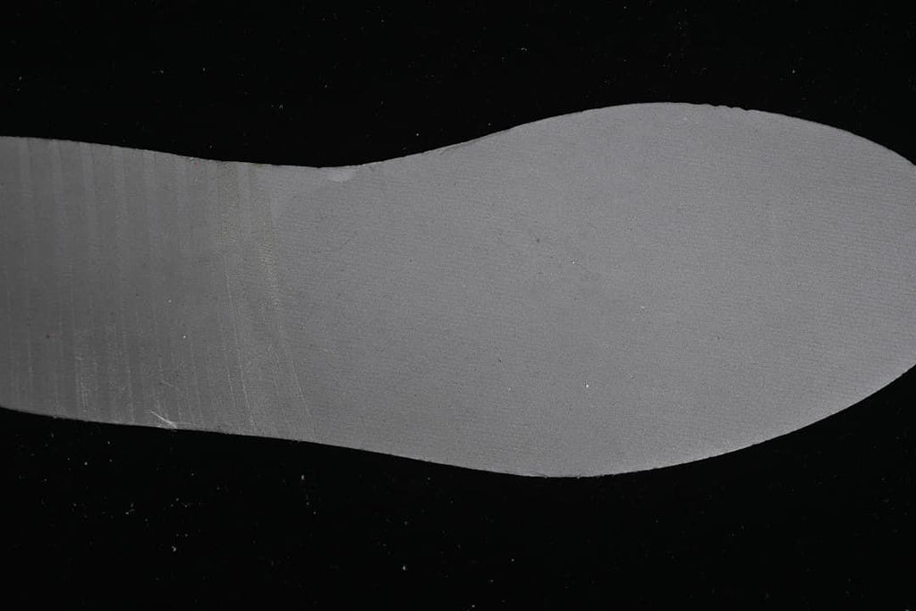 Gray shoe-shaped piece displayed against a black background