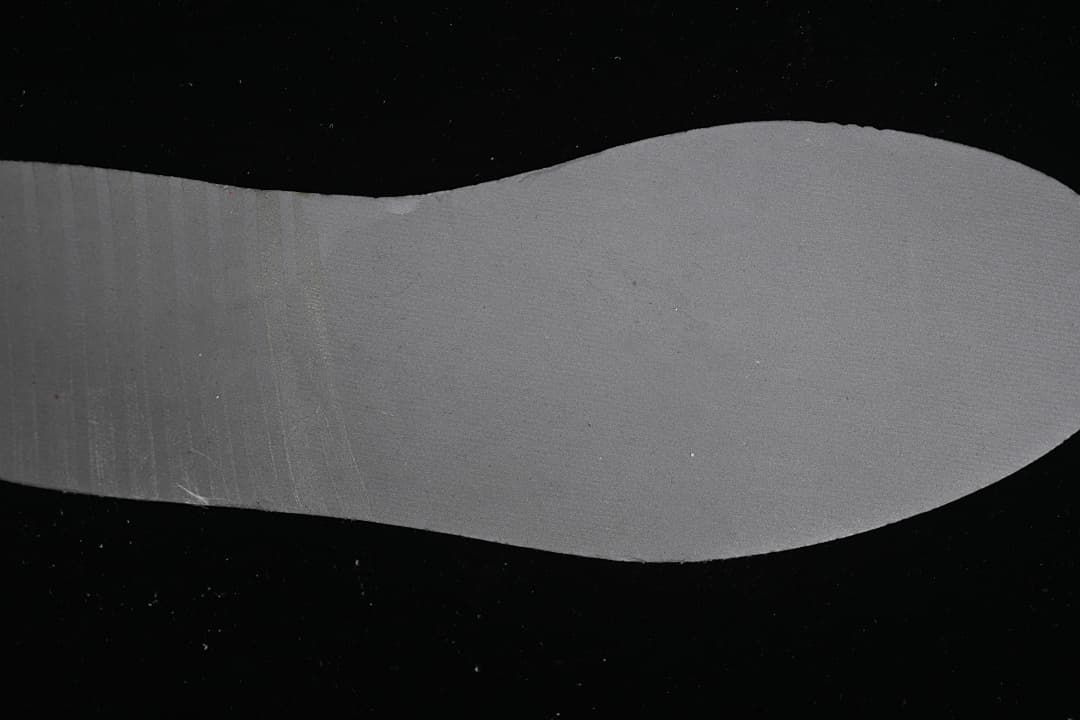 Gray shoe-shaped piece displayed against a black background