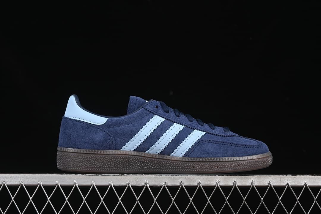 Side profile of a navy sneaker with pale blue stripes and brown sole