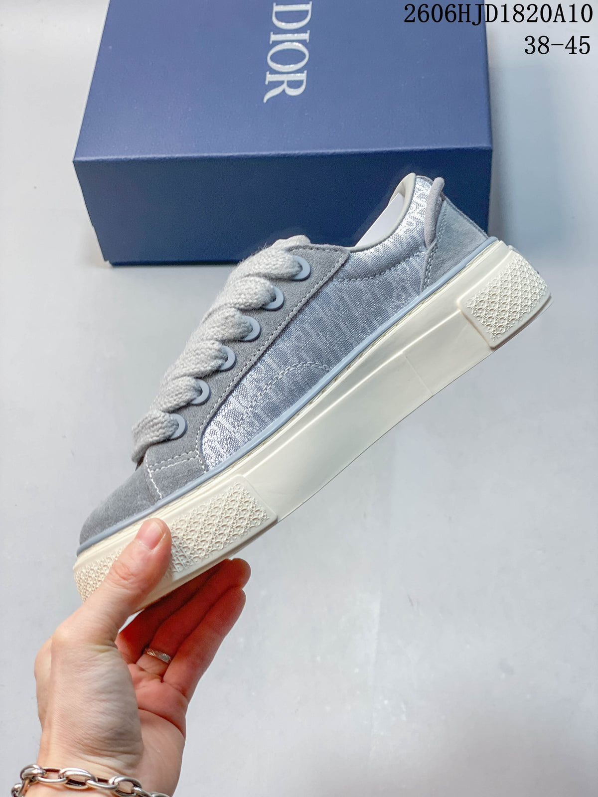 Side view of a gray low-top sneaker with a patterned upper and off-white sole