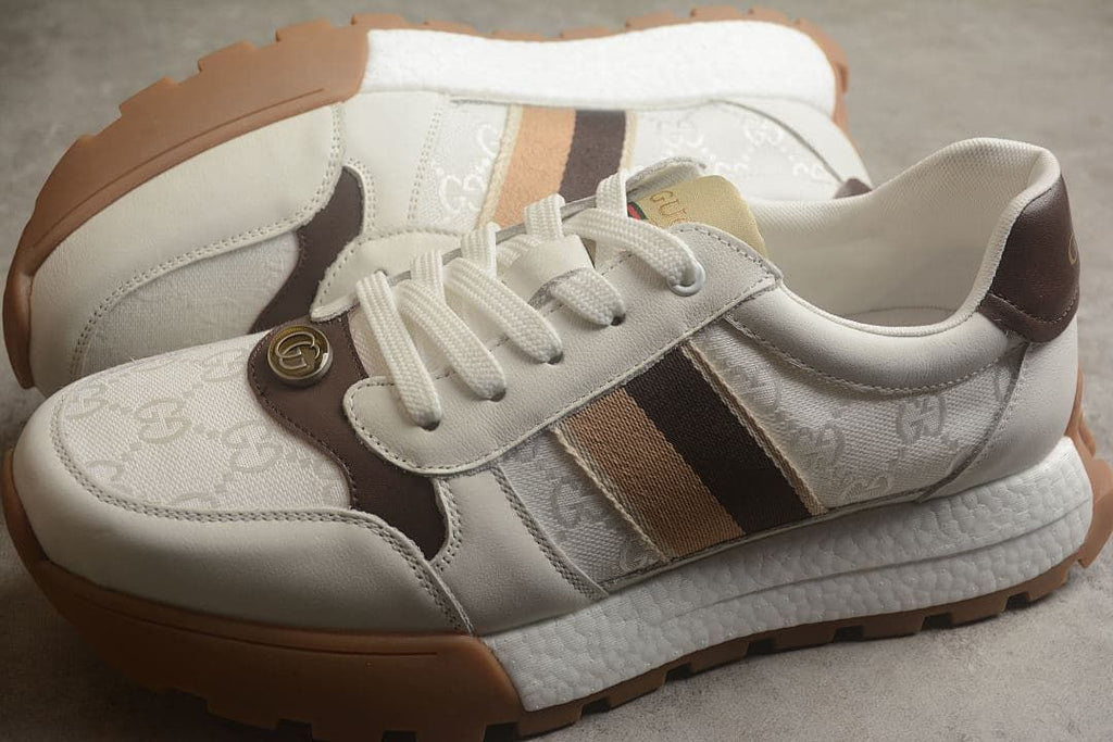 Pair of ivory and brown low-top sneakers shown from the side