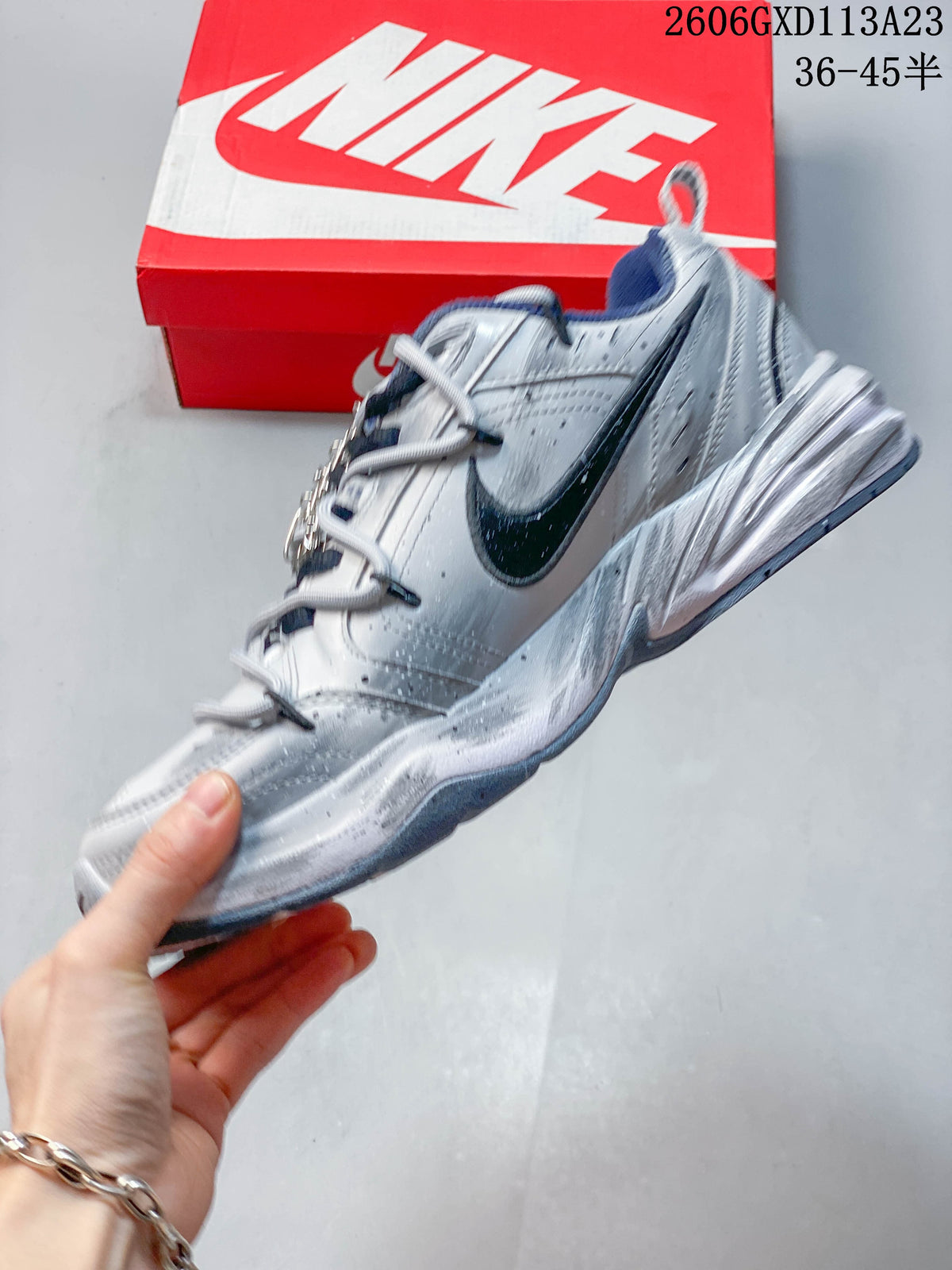Side view of the silver-toned sneaker with a dark Swoosh and layered panels.