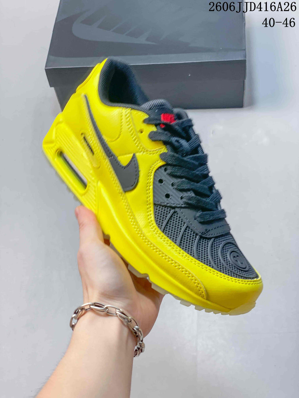 Bright yellow Nike Air Max 90 sneaker with dark gray details.