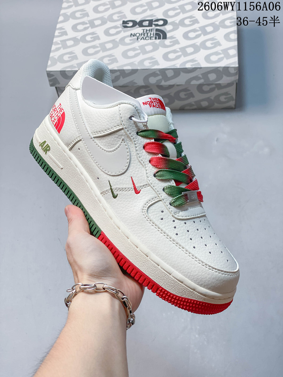 Angled side view of a white low-top sneaker with red and green accents