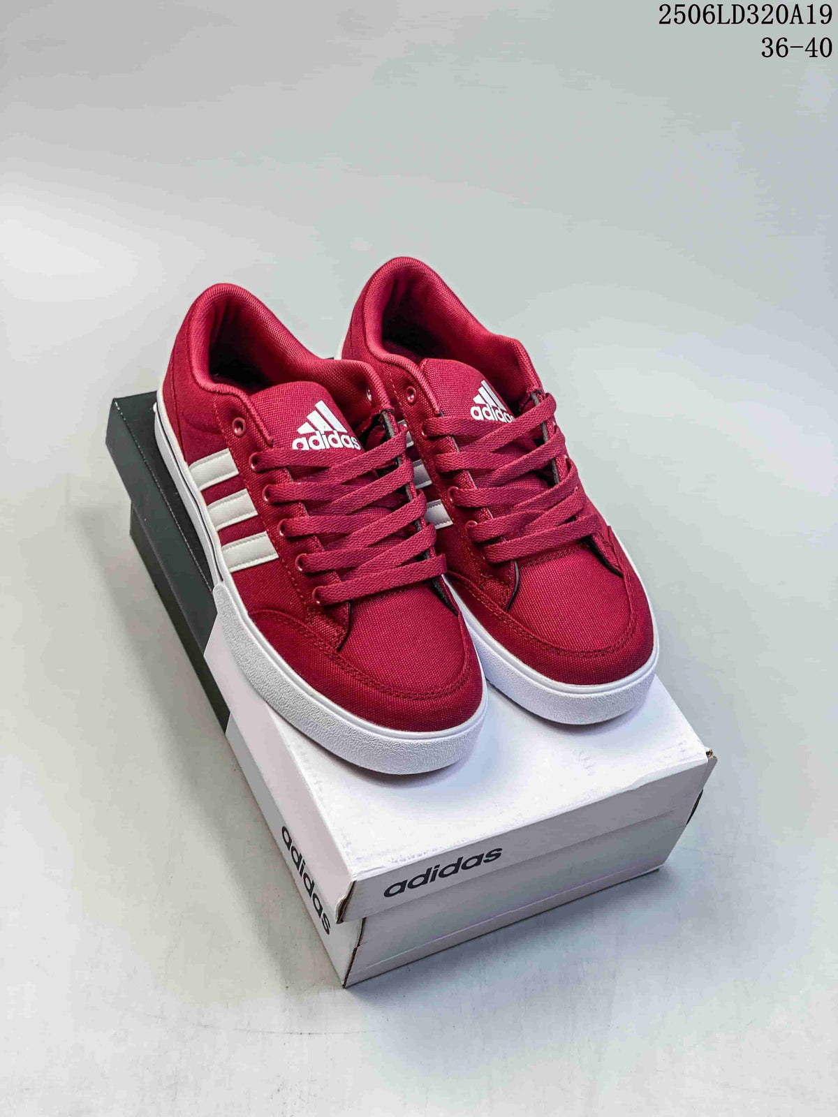 Pair of burgundy adidas low-top sneakers with white side stripes and white soles, shown on a shoebox.