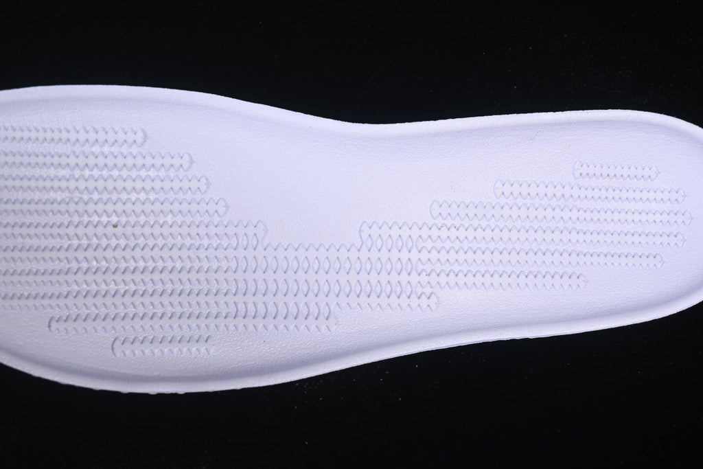 Close-up of the textured surface of a light-colored shoe component.
