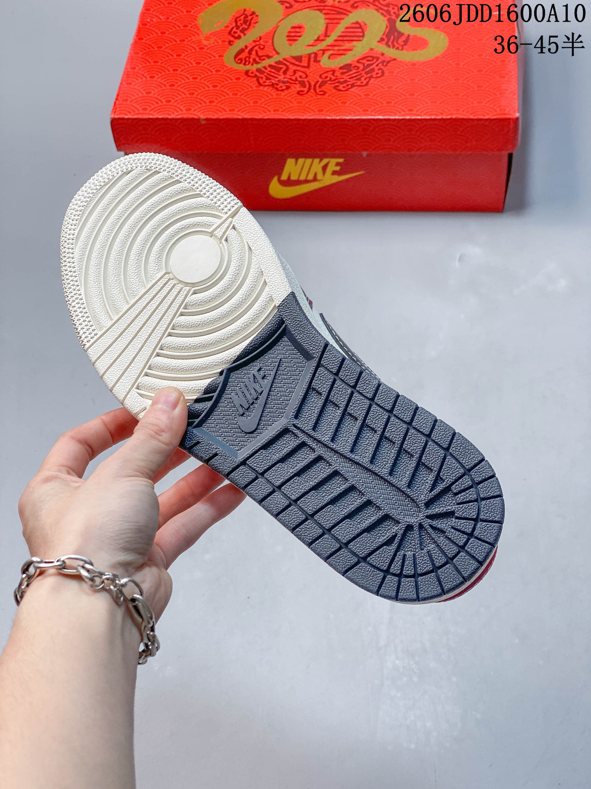 View of the sneaker outsole with circular tread and a dark grey heel section