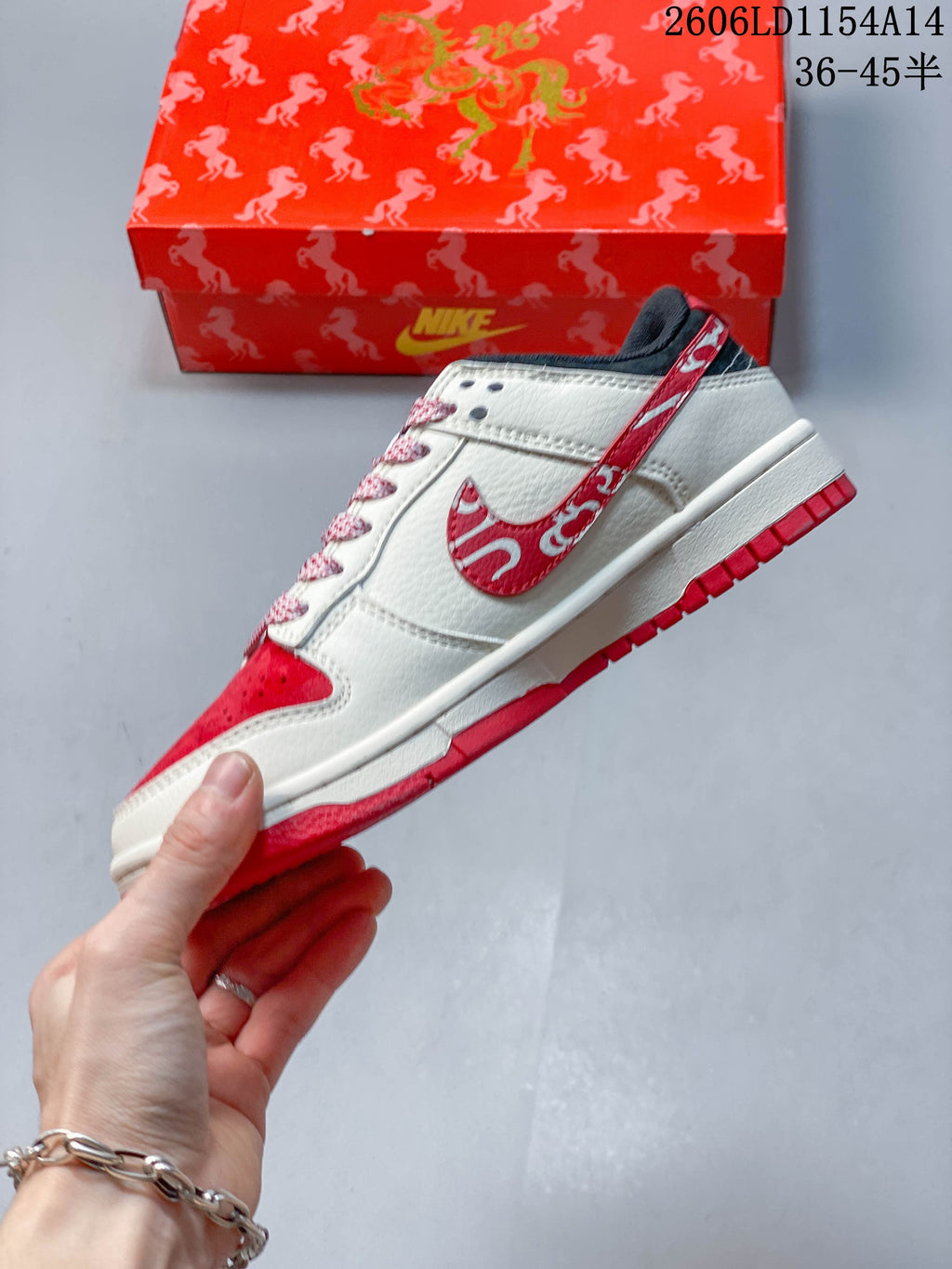 Side view of a cream and red low-top sneaker with patterned accents and a red outsole