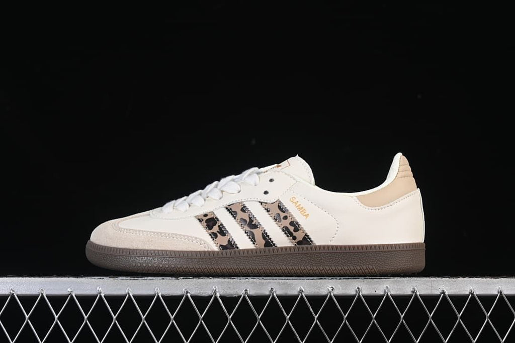 Side view of off-white adidas Samba OG sneakers with leopard-print stripes and dark brown soles