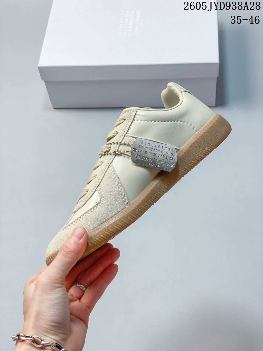 Side view of a cream low-top sneaker with textured panels