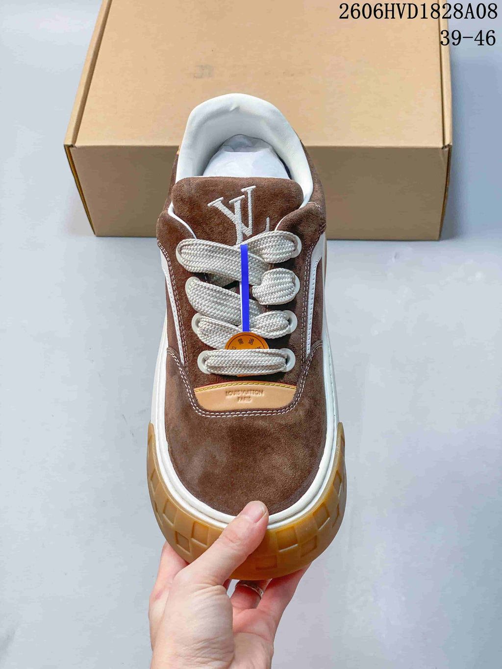 Top view of a brown sneaker with thick white laces and tongue lettering