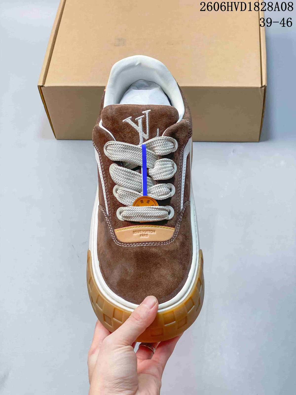Top view of a brown sneaker with thick white laces and tongue lettering