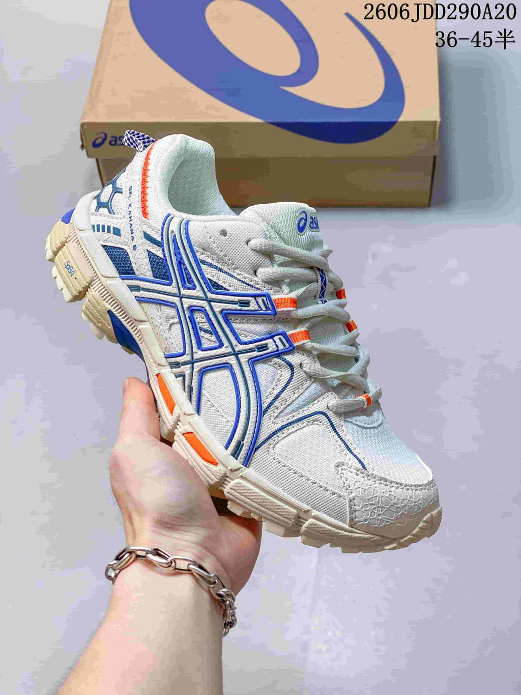 Angled view of the white ASICS sneaker showing its blue side overlays and treaded sole.
