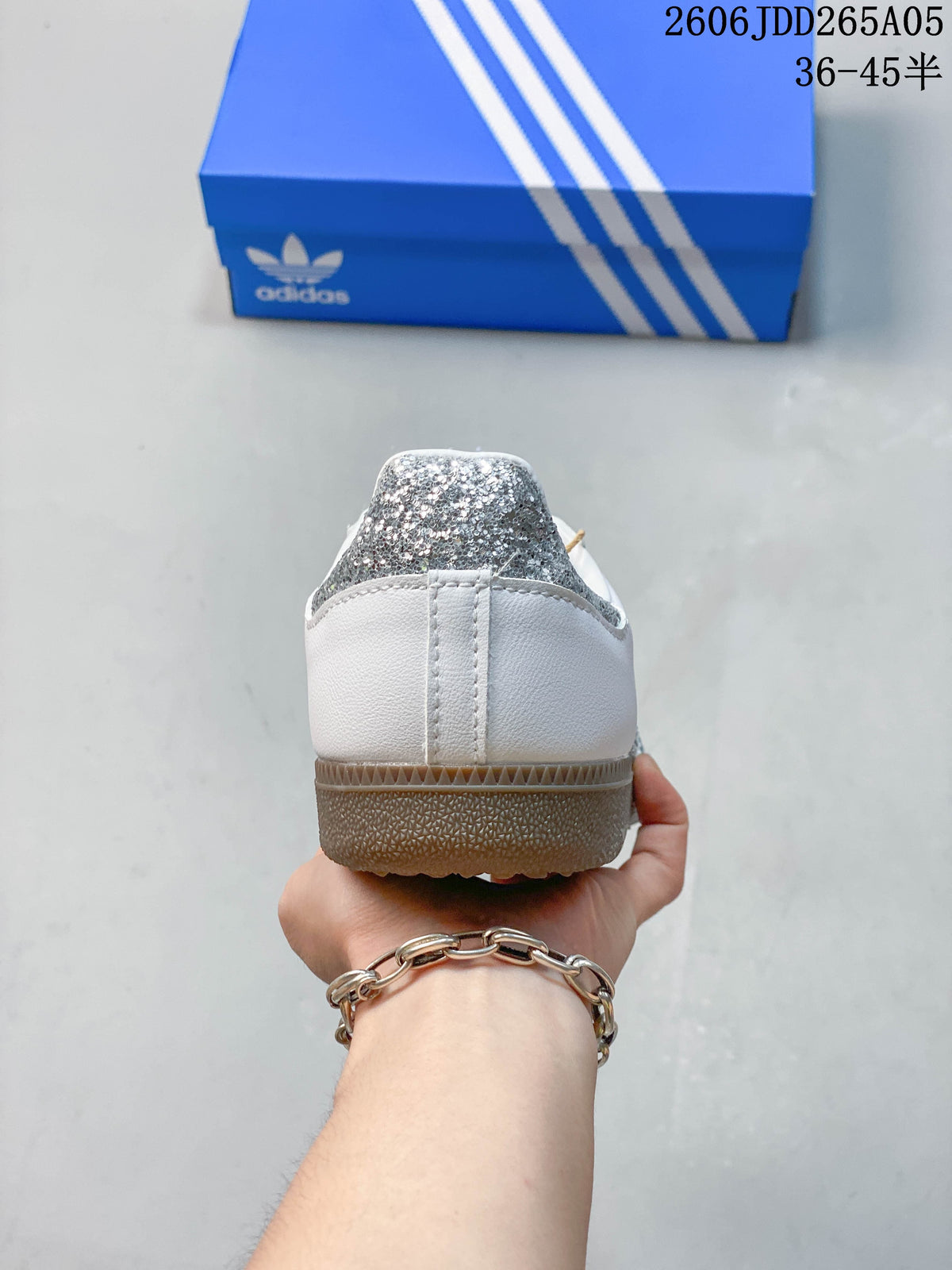 Rear view of a white Samba OG sneaker with a silver-look heel accent and gum-colored outsole.