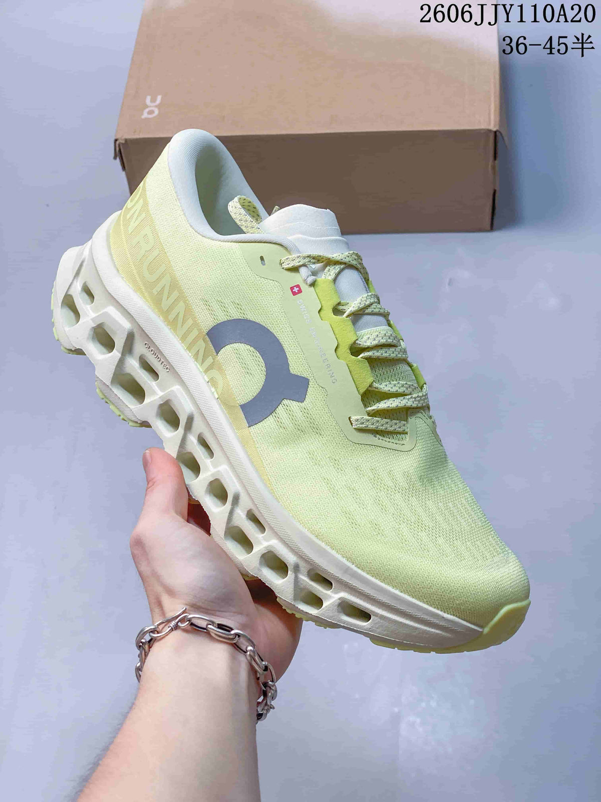 Pale yellow-green On running shoe with light laces and a white cutout-style sole