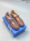 Pair of brown adidas Samba Jane sneakers with Mary Jane-style straps on a blue box