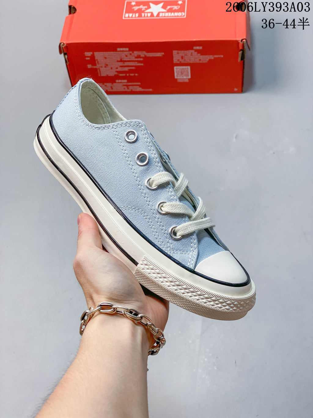 Light blue low-top Converse-style lace-up sneaker with an off-white sole and black stripe
