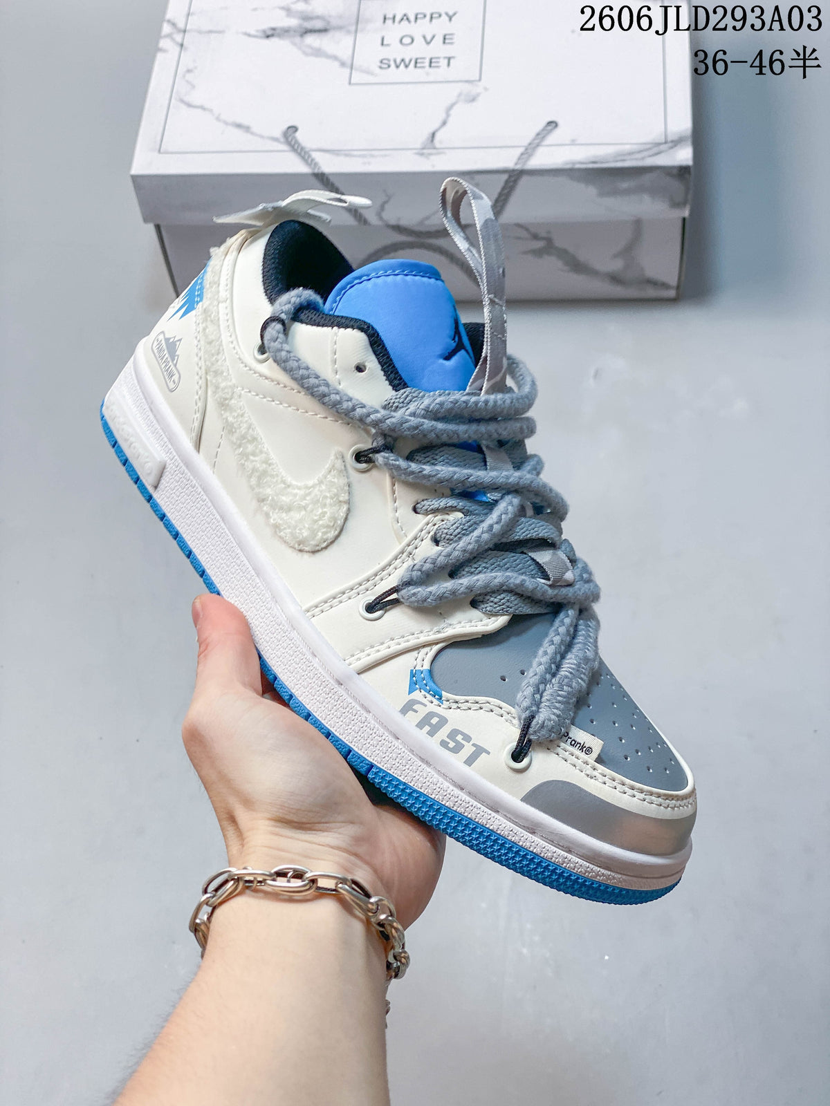 Angled side view showing the white and gray upper with blue accents