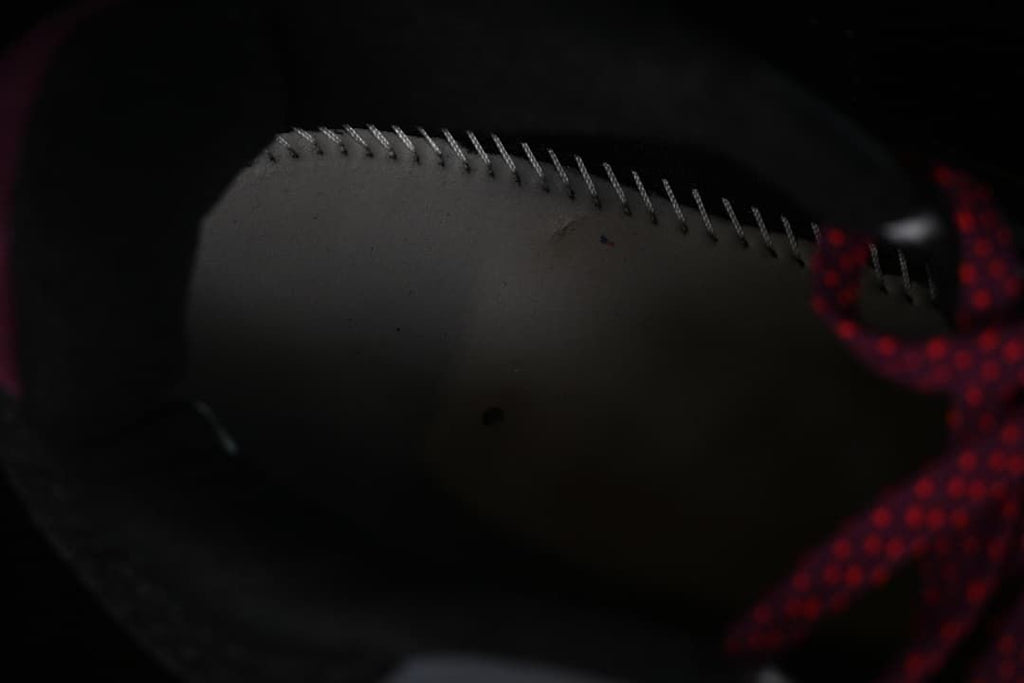 Close-up of stitching and burgundy patterned laces