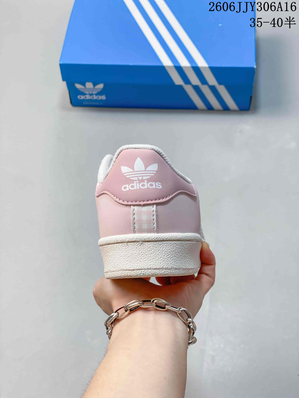 Rear view of a pale pink sneaker with Adidas branding