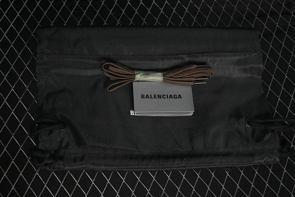 Black drawstring shoe bag and spare brown laces with a Balenciaga booklet