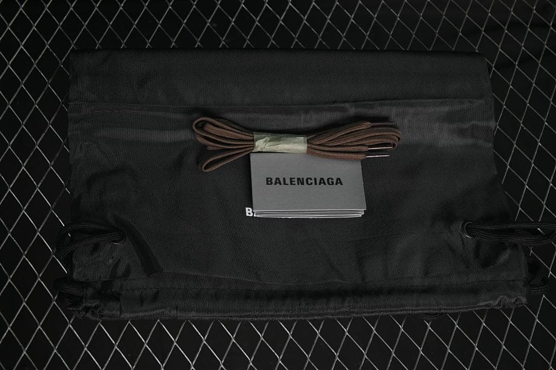 Black drawstring shoe bag and spare brown laces with a Balenciaga booklet