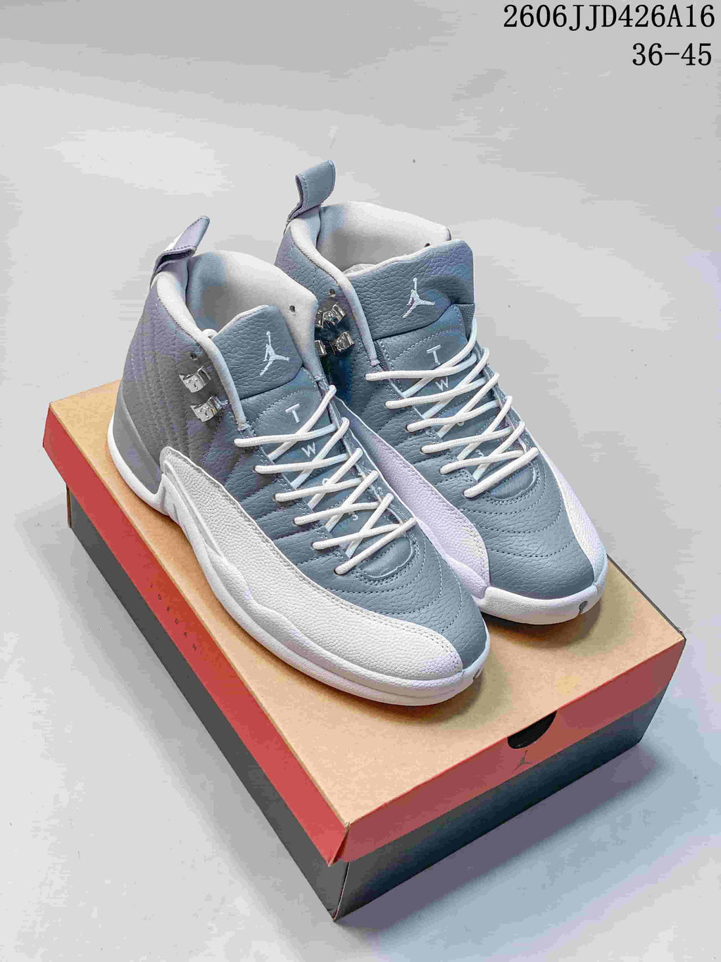 Pair of gray and white high-top sneakers with white laces and metallic side hardware