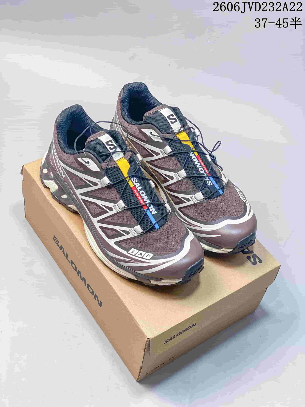 Pair of brown and gray Salomon XT-6 shoes on a box, viewed from above at an angle.